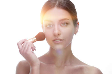 Close-up of a beautiful woman with a make-up brush