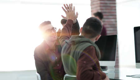 business colleagues giving each other high fiveの写真素材