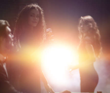 young people with glasses of wine in a casinoの写真素材