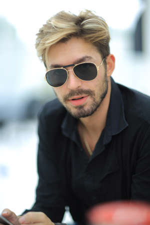 Businessman sitting in park using mobile phoneの写真素材