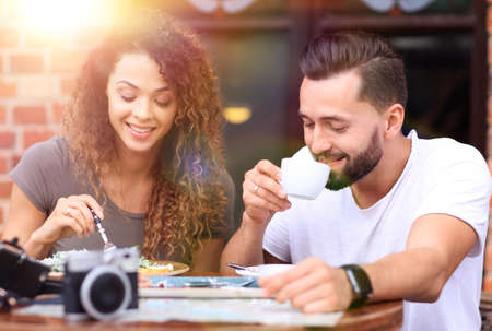Young couple enjoying coffee at a street cafe and  laughingの写真素材