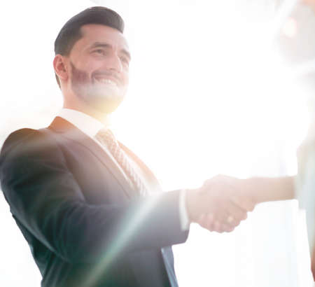 Two business workers shake hands in officeの写真素材