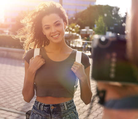 Beautiful brown curly hair  woman posing in cityの写真素材