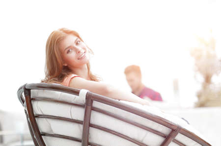 portrait of young woman sitting in a large comfortable chair.