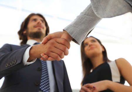 Businesspeople  shaking hands against room with large window looの写真素材