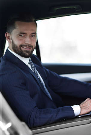 Close-up of a businessman with a laptop sitting in the carの写真素材
