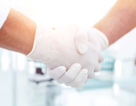 Handshake with white medical gloves