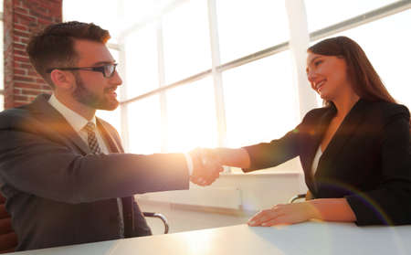 Friendly smiling business people  handshaking after pleasant talの写真素材