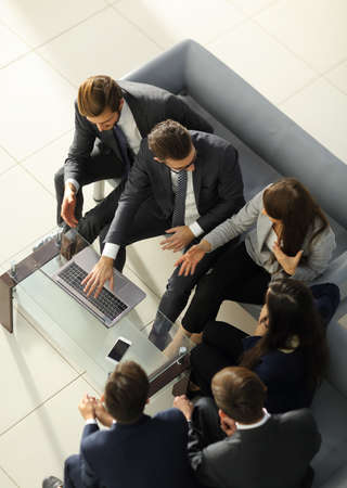manager smiling with a laptop and his business team.の写真素材