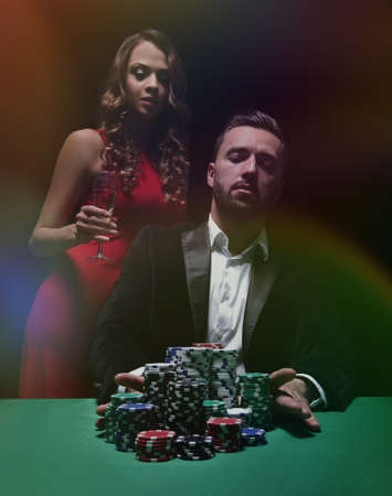 woman and man at the poker table with chips and drinksの写真素材