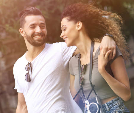Cheerful young couple walking on urban streetの写真素材