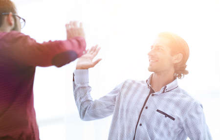 two business men giving each other a high five.の写真素材