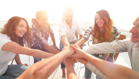 group of employees with hands clasped together.