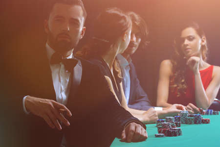 Man with cigar looking up from poker game in casinoの写真素材