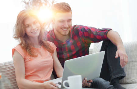 young couple .working on laptop sitting on sofaの写真素材