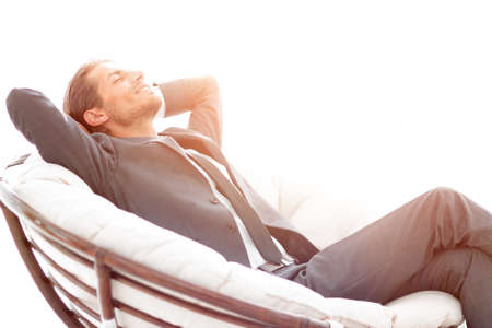 young businessman sitting in large comfortable armchair.の写真素材