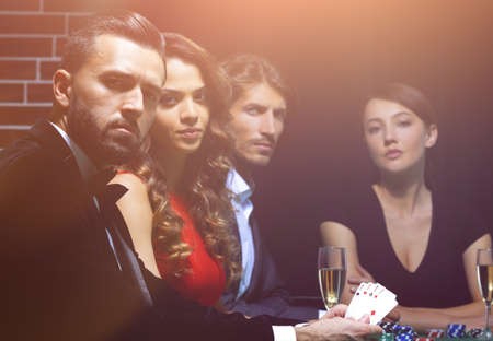 side view of group of people playing poker together in casino