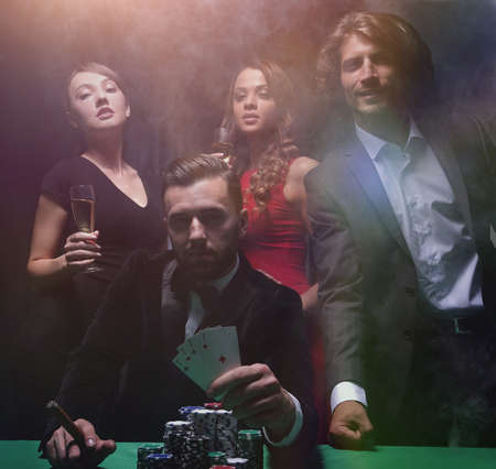 Rich handsome man smoking cigar and playing in the casino