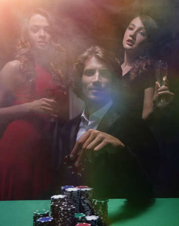 fortunate gambler surrounded by seductive elegant womenの写真素材