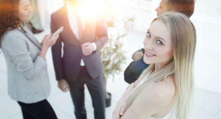 successful young woman - a company employee against the backdrop of colleagues