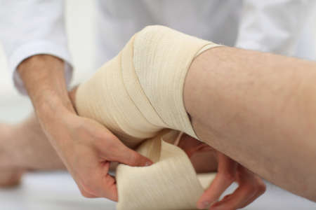 closeup. doctor bandaging a patients legの写真素材