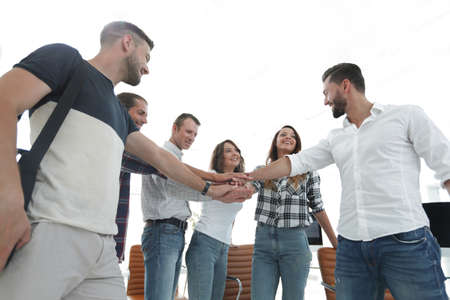 .friendly team of designers clasped their palms togetherの写真素材
