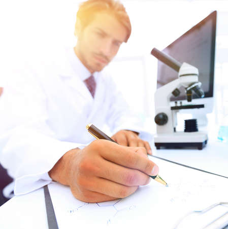 scientist makes a note of experiment in the laboratoryの写真素材