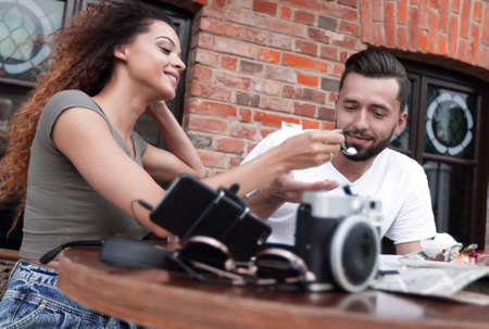 Young tourists eating breakfast at restaurant table outside side