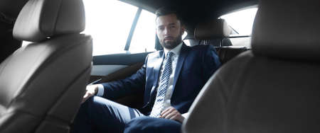 businessman sitting in the back seat of a carの写真素材
