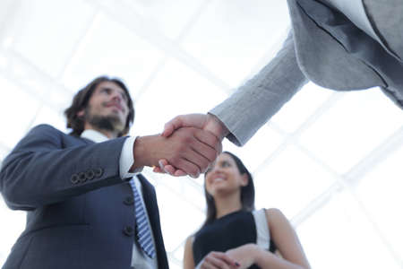 Businesspeople  shaking hands against room with large window looの写真素材