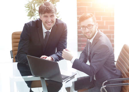 Portrait of business colleagues sitting at work deskの写真素材