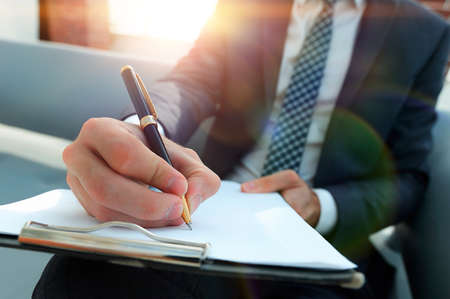 Businessman signs a contract. Holding pen in hand.の写真素材