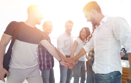 .friendly team of designers clasped their hands together