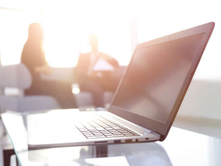 Focus on laptop on the table. Blurred people on background.の写真素材