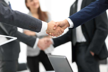 Men shaking hands with smile at office with their coworkers.の写真素材