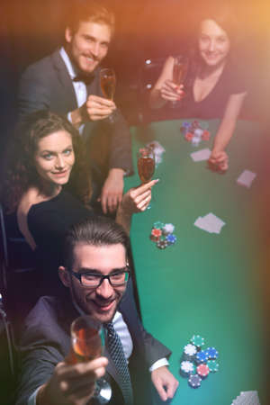 Group of young rich people is playing poker in the casinoの写真素材