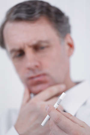 background image of serious businessman looking cigarette.の写真素材