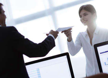 senior Manager, handing the employee a document with financial data.