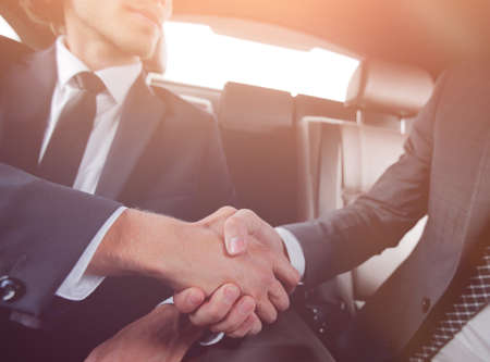 handshake of business partners sitting in the carの写真素材