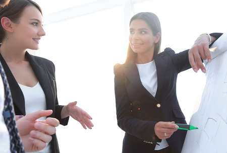 business woman pointing with a marker on the flipchart