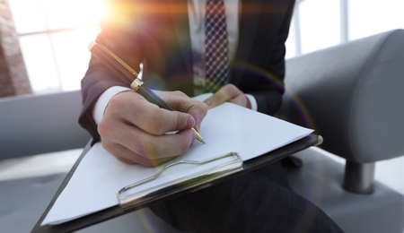 Businessman signs a contract. Holding pen in hand.の写真素材