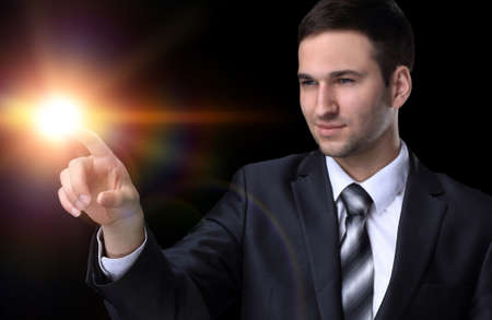 businessman pointing to a blank spot.isolated on a black backgroの写真素材