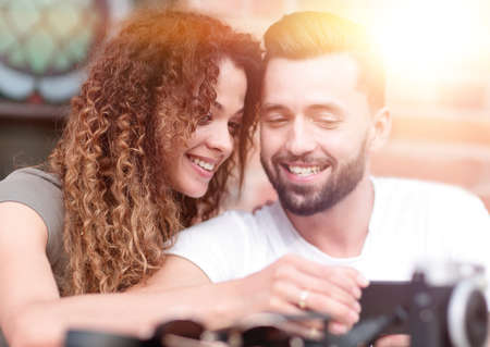 Happy loving  couple using a smartphone sitting in terraceの写真素材
