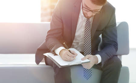 Businessman signs a contract. Holding pen in hand.の写真素材
