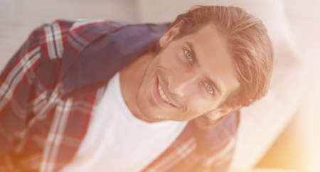 young man working on laptop and looking at camera. view from aboの写真素材