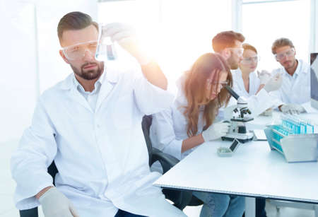 biochemist with flask Petri sitting at a Desk