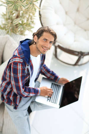 young man working on laptop and looking at camera. view from aboveの写真素材
