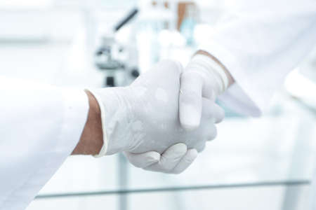 Handshake with white medical glovesの写真素材