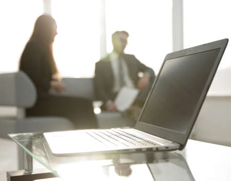Focus on laptop on the table. Blurred people on background.の写真素材