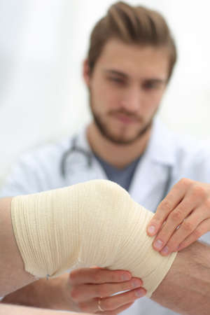 traumatologist examining the bandage on his knee.の写真素材